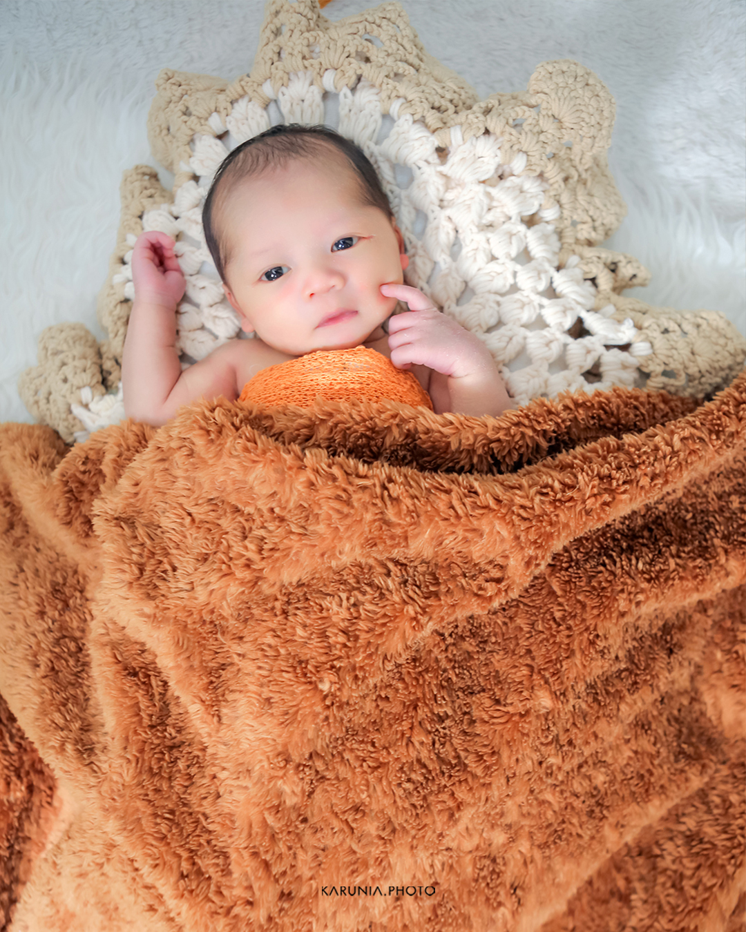 Brother and sister sitting together in a giant chair reading a picture book together